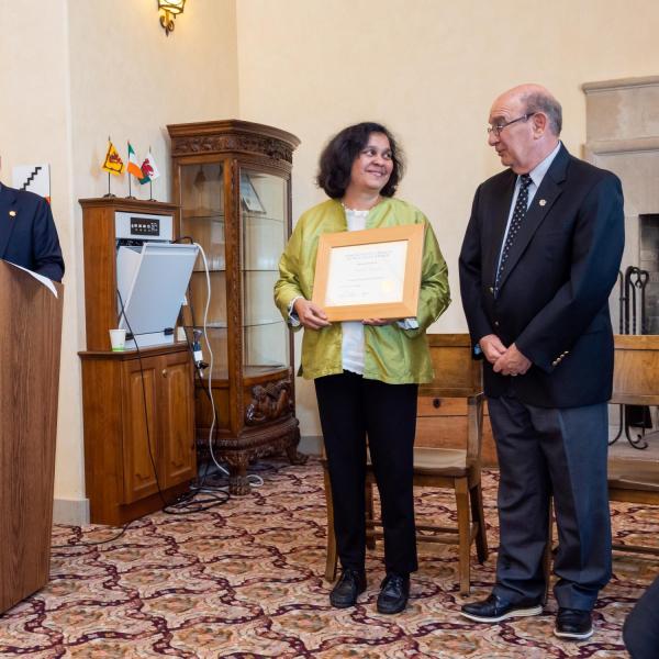 Provost Russell L. Moore, left, and Chancellor Philip P. DiStefano present an award during the 2019 fall convocation celebrating faculty. (Photo by Patrick Campbell/University of Colorado)