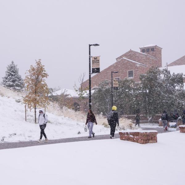 Students make their way to class during the first snowfall of the year on Oct. 10, 2019. (Photo by Patrick Campbell/University of Colorado)