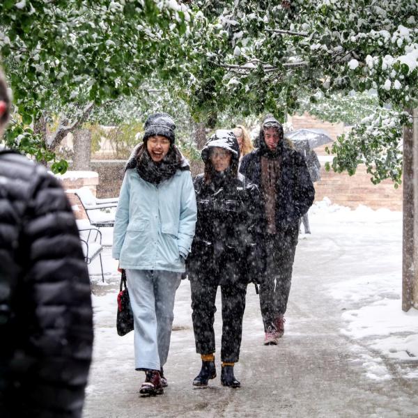 Students make their way to class during the first snowfall of the year on Oct. 10, 2019. (Photo by Patrick Campbell/University of Colorado)
