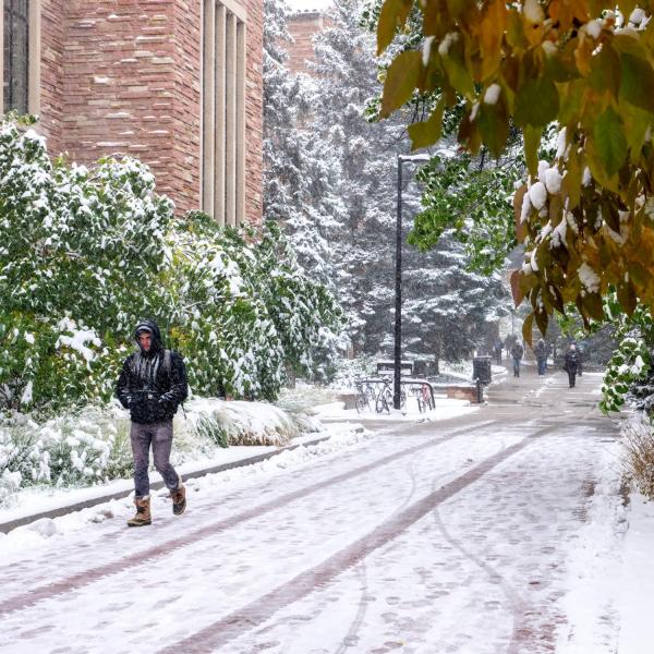 Students make their way to class during the first snowfall of the year on Oct. 10, 2019. (Photo by Patrick Campbell/University of Colorado)