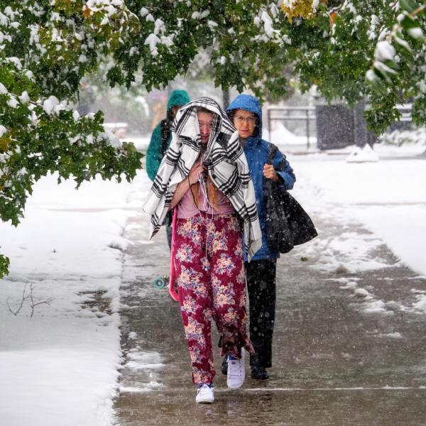Students make their way to class during the first snowfall of the year on Oct. 10, 2019. (Photo by Patrick Campbell/University of Colorado)