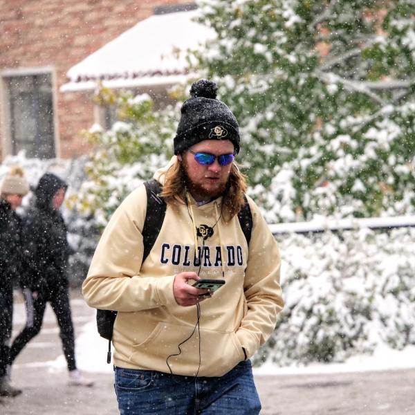 Students make their way to class during the first snowfall of the year on Oct. 10, 2019. (Photo by Patrick Campbell/University of Colorado)