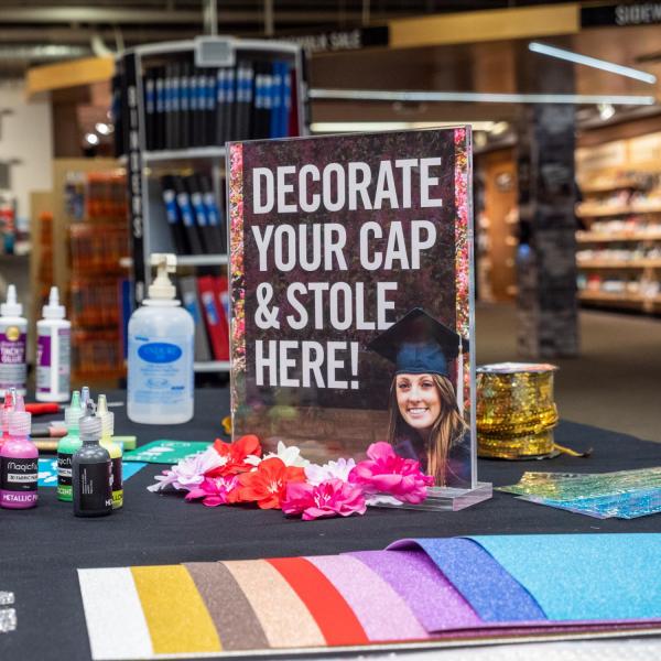 Students decorate their graduation caps and stoles at the University Bookstore. (Photo by Patrick Campbell/University of Colorado)