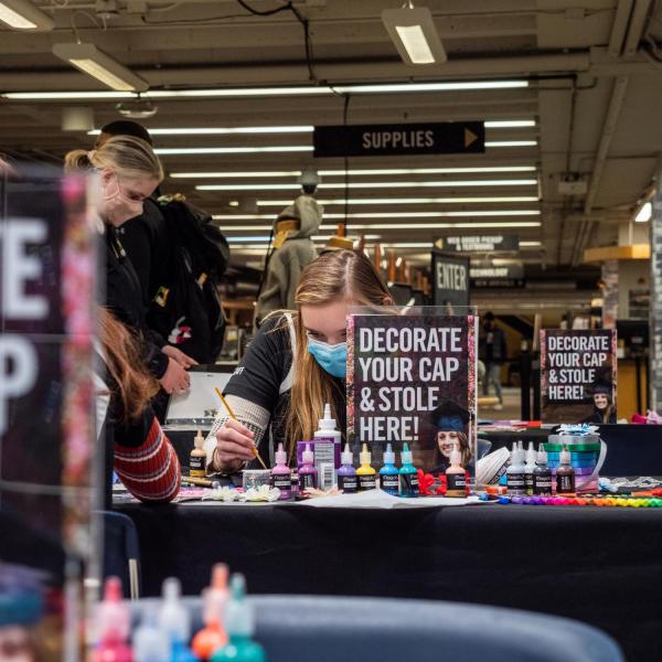 Students decorate their graduation caps and stoles at the University Bookstore. (Photo by Patrick Campbell/University of Colorado)