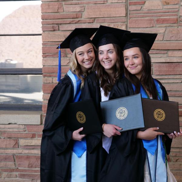 Accounting graduate Alexa Reber, left, political science and anthropology graduate Katie Burns, center, and finance graduate Claudia Hall, right, pose for a friend’s photo during CU Boulder’s Graduate Appreciation Days events. (Photo by Glenn Asakawa/University of Colorado)