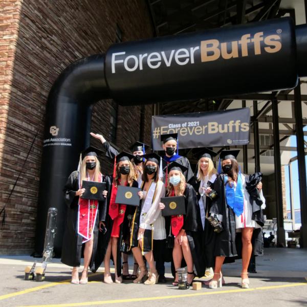 Graduates gather for a group shot after getting their individual portraits taken on Folsom Field during CU Boulder’s Graduate Appreciation Days events. (Photo by Glenn Asakawa/University of Colorado)