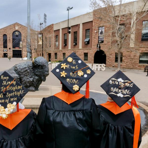 International chemical engineering graduates from Malaysia (from left) Nur Alwani, Adam Izz Khan, and Nur SyrahHirah, display their inspirational messages on their caps during CU Boulder’s Graduate Appreciation Days events. (Photo by Glenn Asakawa/University of Colorado)