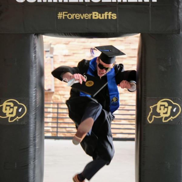 Matt Wolff leaps through an inflatable photo frame during CU Boulder’s Graduate Appreciation Days events. (Photo by Glenn Asakawa/University of Colorado)