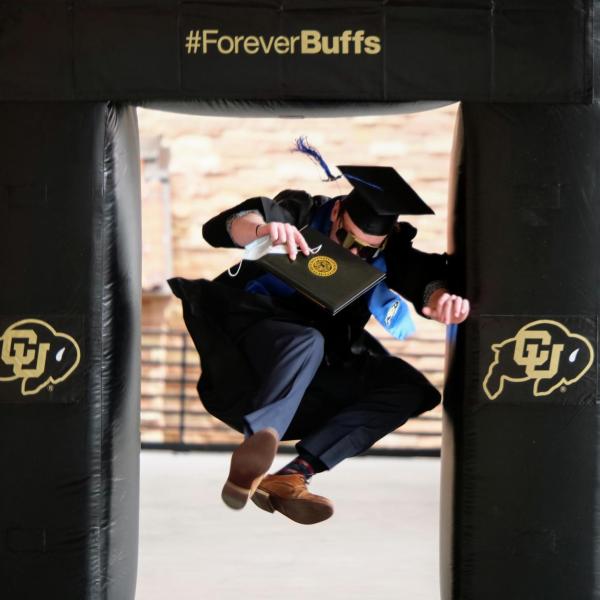 Matt Wolff leaps through an inflatable photo frame during CU Boulder’s Graduate Appreciation Days events. (Photo by Glenn Asakawa/University of Colorado)