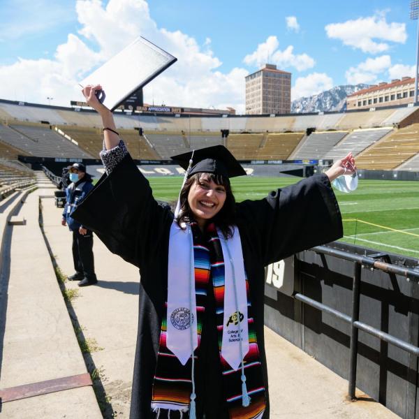 Valeria Ayala Alonso, a molecular biology and psychology double major, celebrates after getting her photo taken at Folsom Field during CU Boulder’s Graduate Appreciation Days events. (Photo by Glenn Asakawa/University of Colorado)
