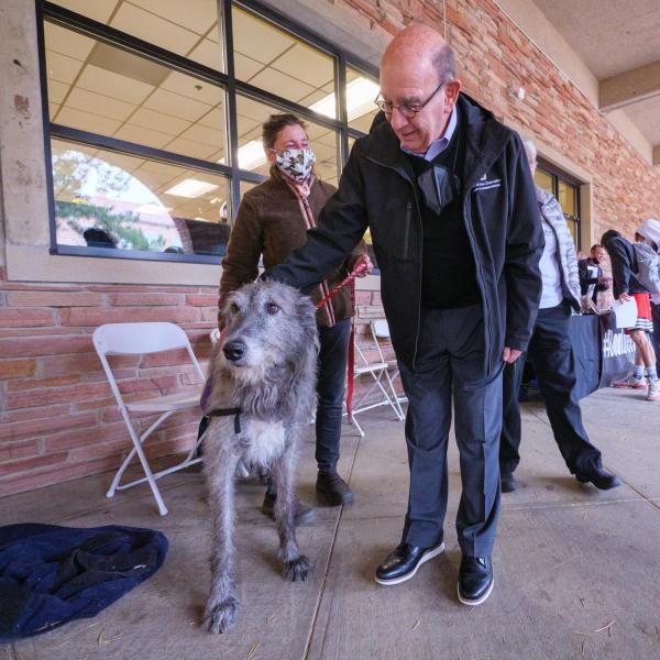 Chancellor Phil DiStefano pets a therapy dog during the Health Hut event, part of the 2021 Health and Wellness Summit on the CU Boulder campus. (Photo by Glenn Asakawa/University of Colorado)