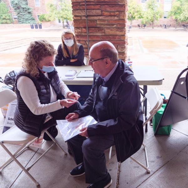 Chancellor Phil DiStefano gets acupuncture ear seeds placed on pressure points in his ear during a visit to an acupuncture wellness table at the Health Hut event. (Photo by Glenn Asakawa/University of Colorado)