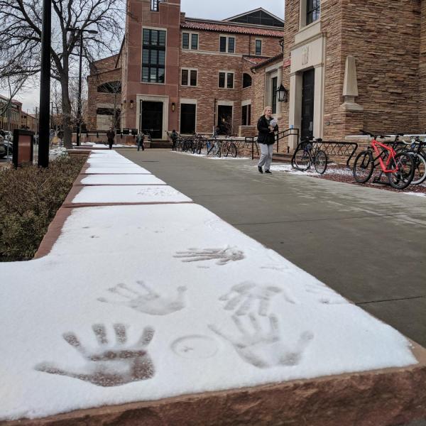 Handprints in the snow with the ATLAS tower in the background. Photo by Patrick Campbell.