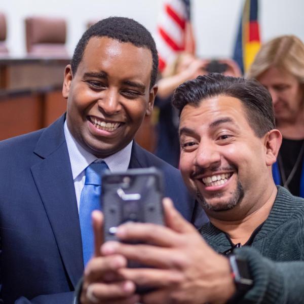 A happy supporter gets a selfie following a ceremonial swearing-in event for U.S. Representative Joe Neguse. Photo by Glenn Asakawa.