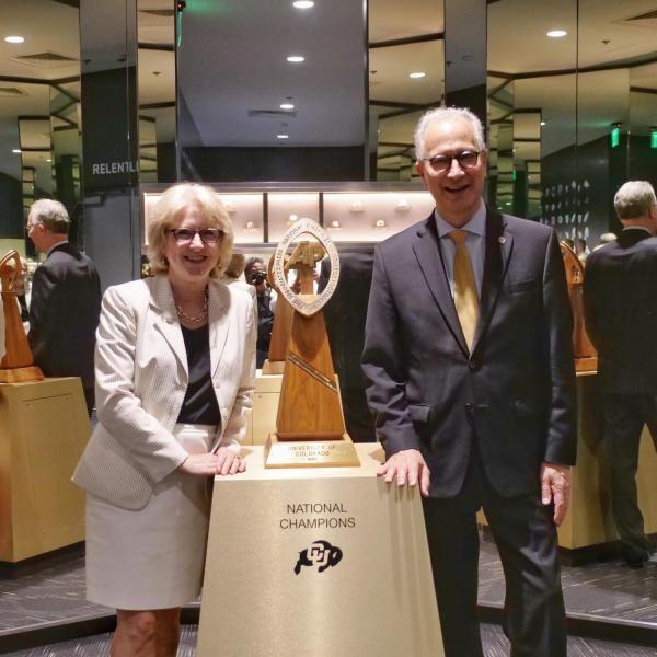 CU President Mark Kennedy, right, and CU First Lady Debbie Kennedy pose next to the 1990 Football National Champions trophy during a tour of campus. (Photo by Glenn Asakawa/University of Colorado)