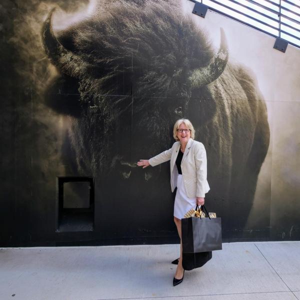 Debbie Kennedy, wife of CU President Mark Kennedy, poses next to a mural of Ralphie. (Photo by Glenn Asakawa/University of Colorado)