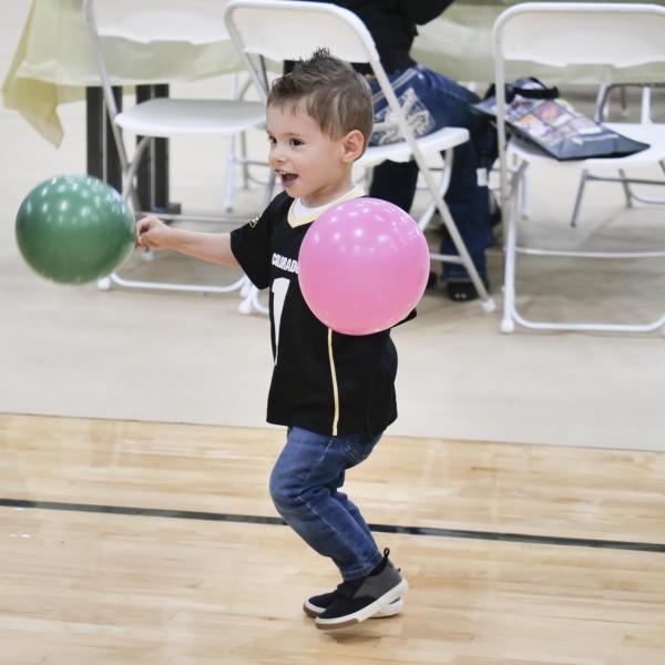 A child frolics with balloons. (Photo by Casey A. Cass/University of Colorado)