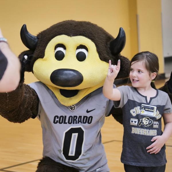 A fan takes a photo with Chip at Campus Kids Day. (Photo by Casey A. Cass/University of Colorado)