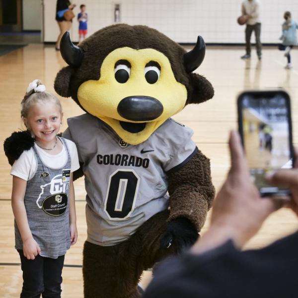 A fan takes a photo with Chip at Campus Kids Day. (Photo by Casey A. Cass/University of Colorado)