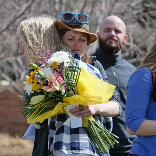 Two attendees embrace during the dedication ceremony.