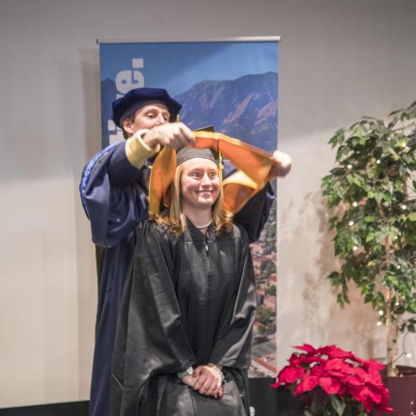A member of the first graduating class of the Masters of the Environment receives her hooding at recognition ceremony