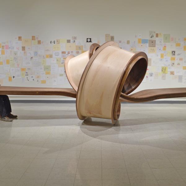 Two men sit at a table with a knot at the center