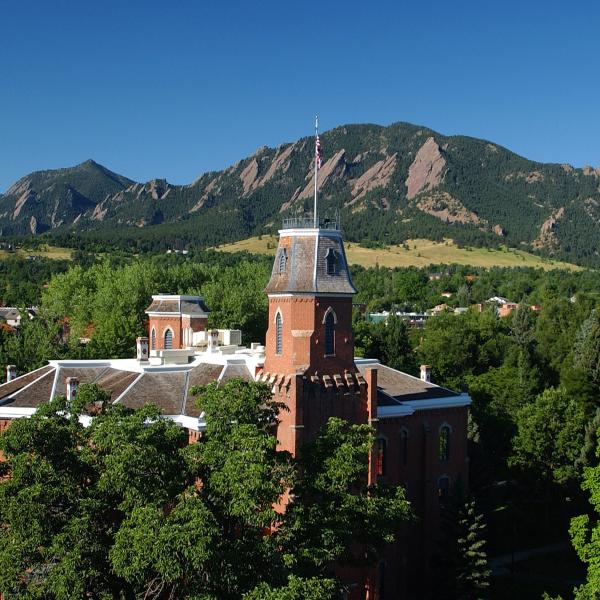 Old Main with green trees, Flatirons in background