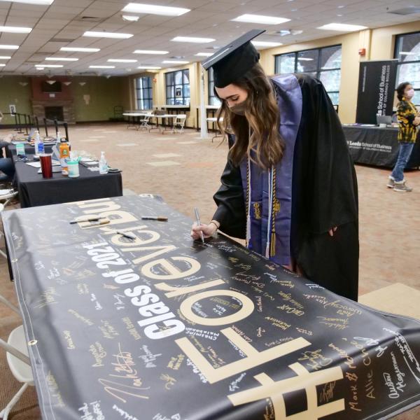 Allie Shea Reuter signs the Class of 2021 banner at the 2021 Graduation Appreciation Days at CU Boulder. (Photo by Casey A. Cass/University of Colorado)