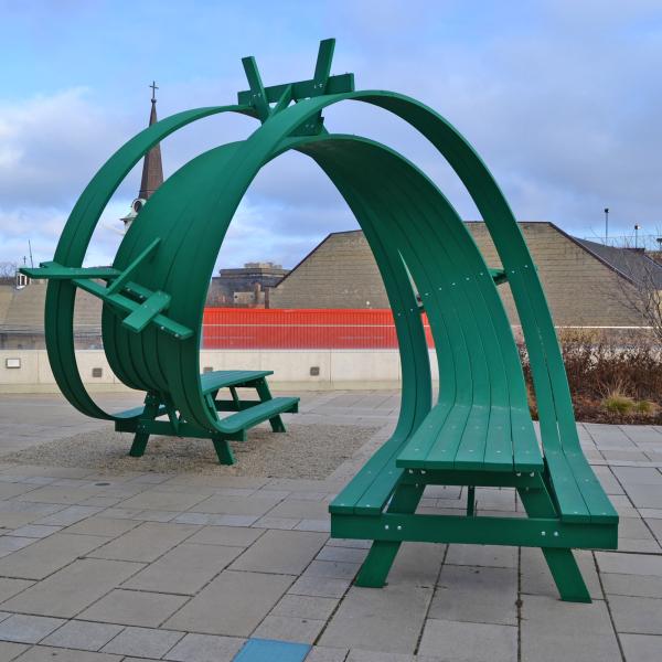 Green picnic table with a roller-coaster like twist