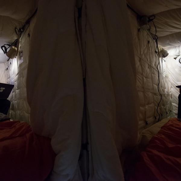 Two test subjects read in cramped sleeping quarters
