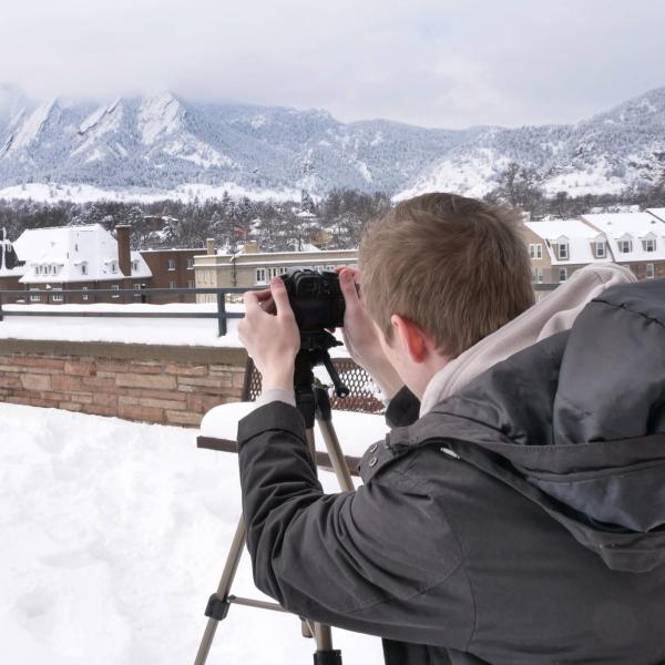 Kevin Ziznewski, a sophomore film and geography double major, snaps some frames of the snow-covered Flatirons. Photo by Patrick Campbell.