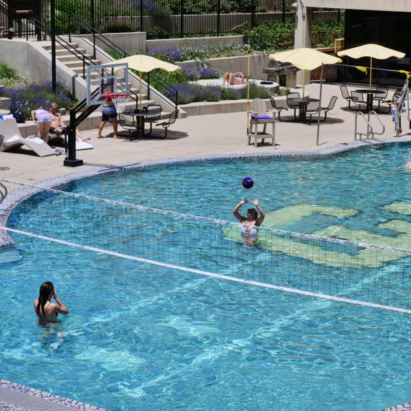 Students play volleyball in the buffalo pool on the first day of summer