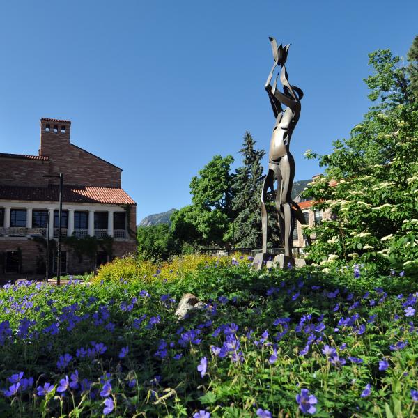 Statue at UMC amid purple flower bed