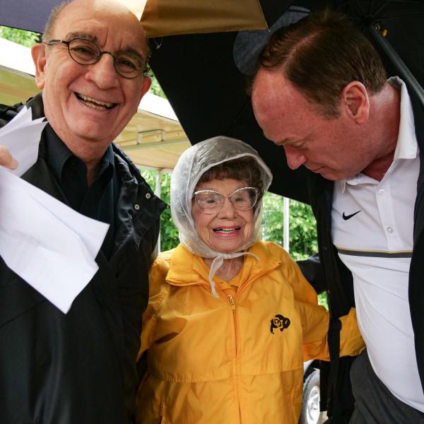 Chancellor Philip DiStefano, left, and Athletic Director Rick George greet Peggy Coppom as they and others gathered on Saturday, June 26, for a tree dedication ceremony honoring Coppom and her late sister Betty Hoover. (Photo by Glenn Asakawa/University of Colorado)