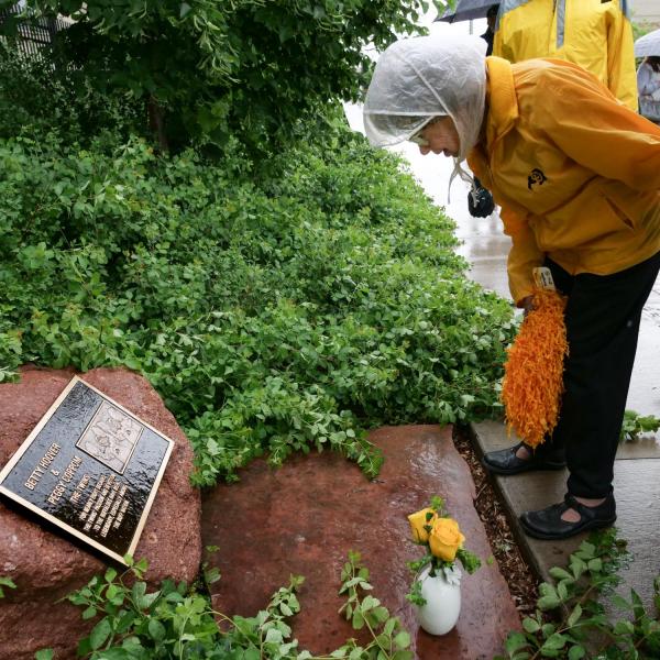 Peggy Coppom looks over a plaque honoring her and her late twin sister, Betty Hoover. (Photo by Glenn Asakawa/University of Colorado)