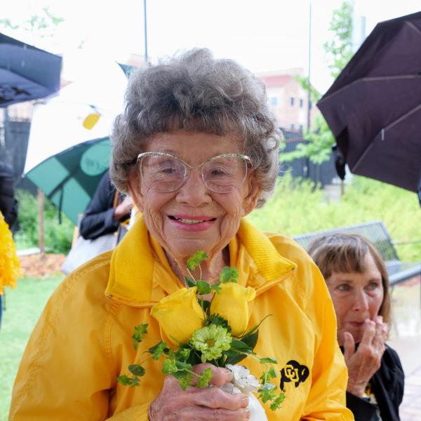 Chancellor Philip DiStefano presents Peggy Coppom with a vase with two yellow roses after he, Athletic Director Rick George and others gathered on Saturday, June 26, for a tree dedication ceremony honoring Coppom and her late sister Betty Hoover. (Photo by Glenn Asakawa/University of Colorado)