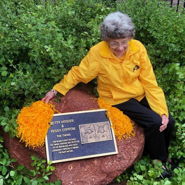 Peggy Coppom sits next to a plaque honoring her and her late twin sister, Betty Hoover. (Photo by Sarah Adderholt/University of Colorado)