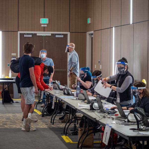 Students check in with ballot judges at a polling place in the Williams Village Center at CU Boulder. (Photo by Patrick Campbell/University of Colorado)