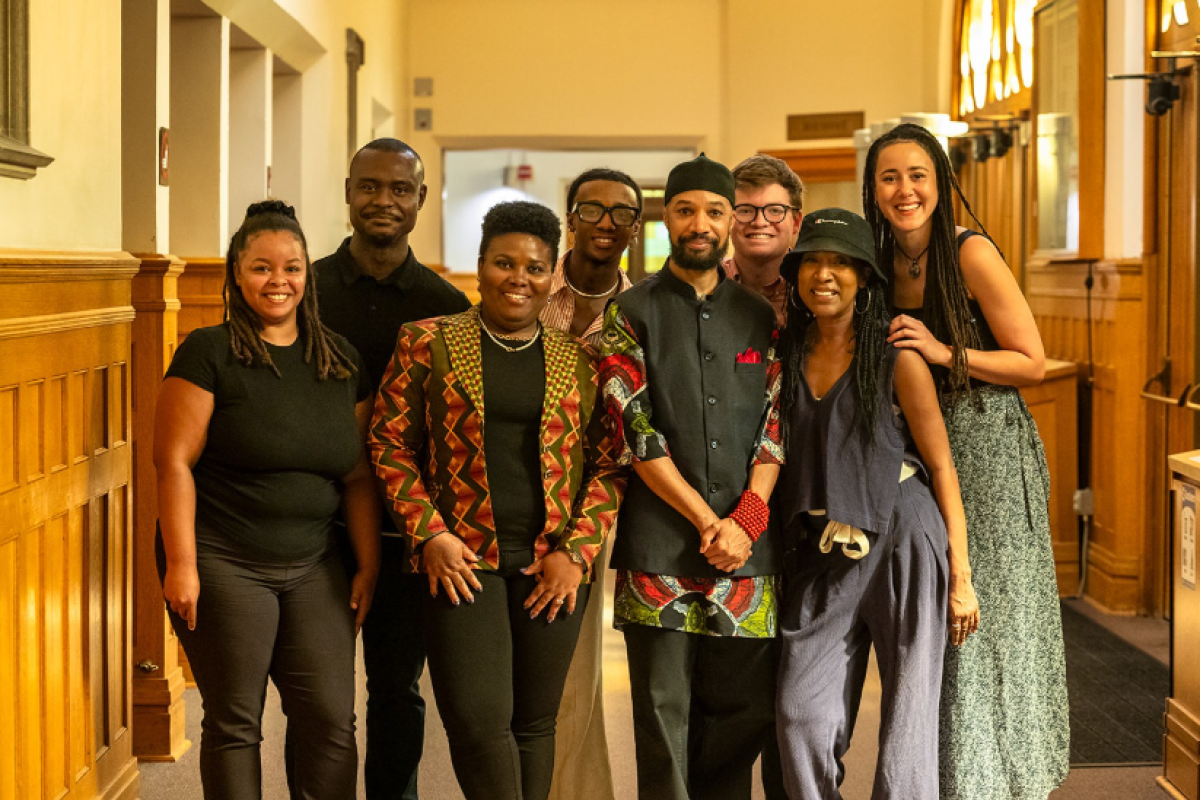 CAAAS Director Reiland Rabaka and seven other people surrounding him stand as a group in a hallway, posing for the camera with smiles.