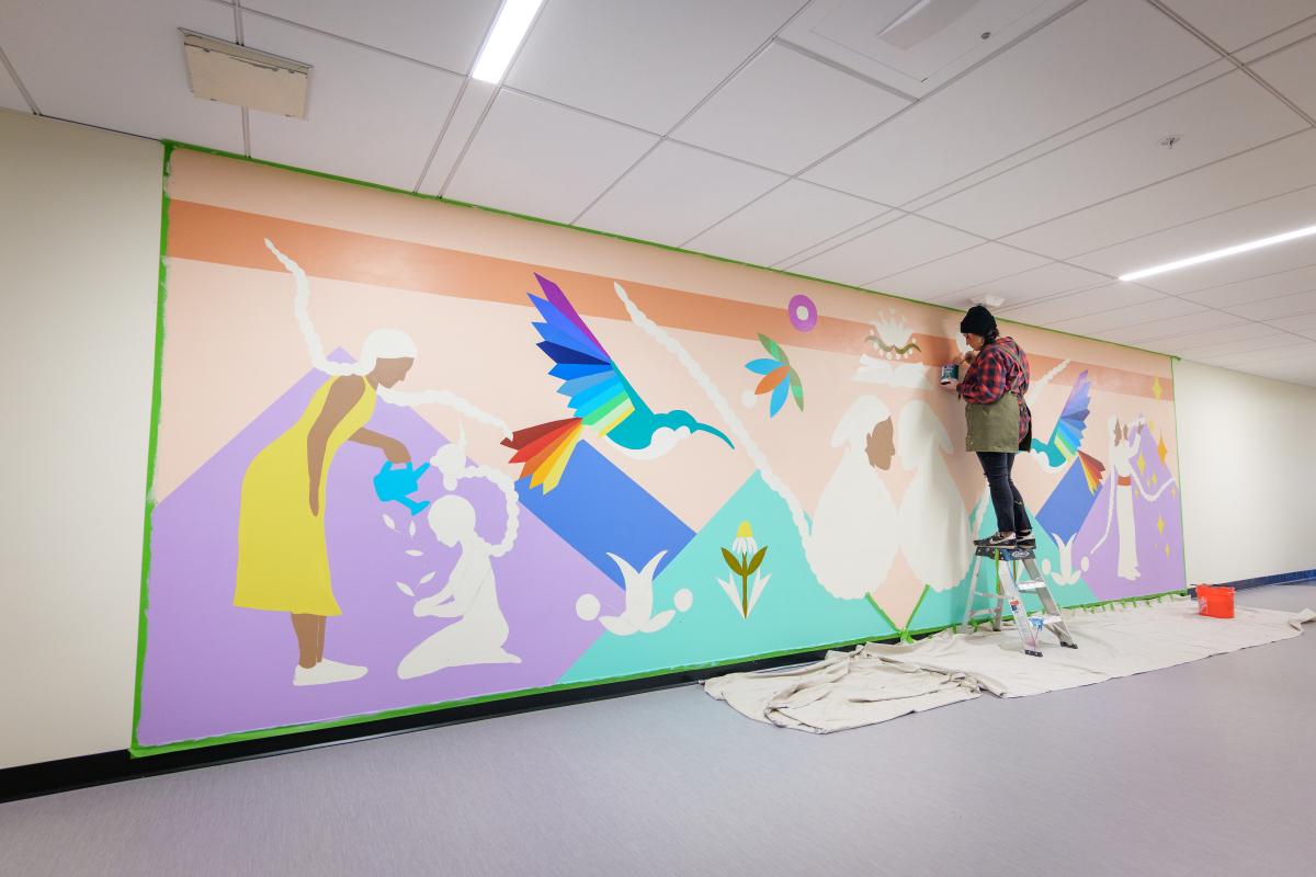 Danielle SeeWalker painting a mural