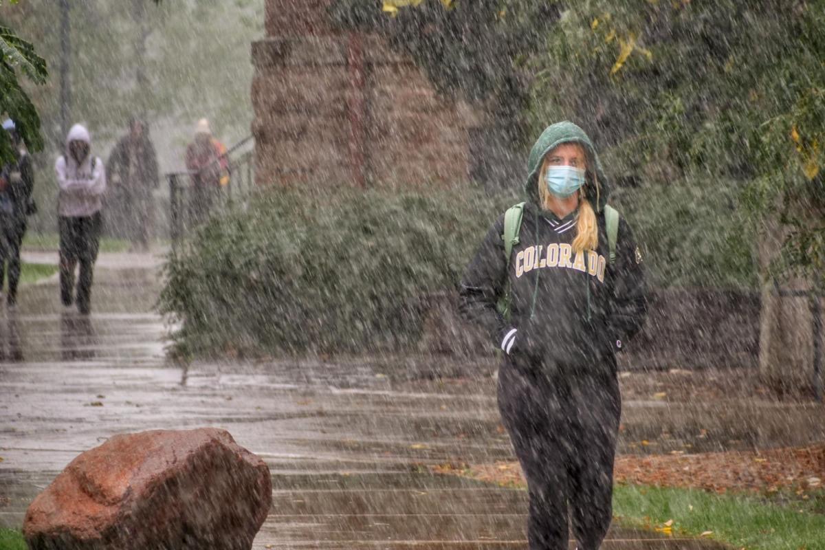 A student walking through the snow on the CU Boulder campus
