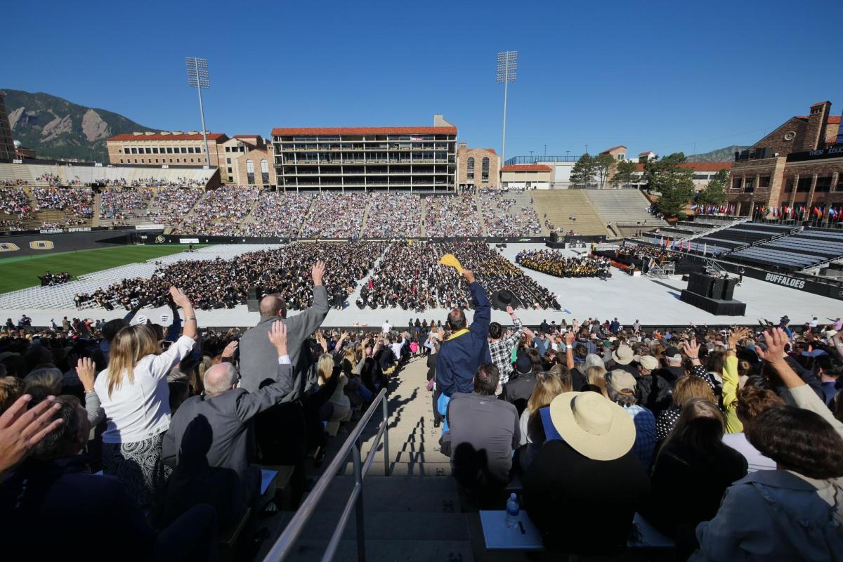 Commencement attendees celebrate in the stands of Folsom Stadium