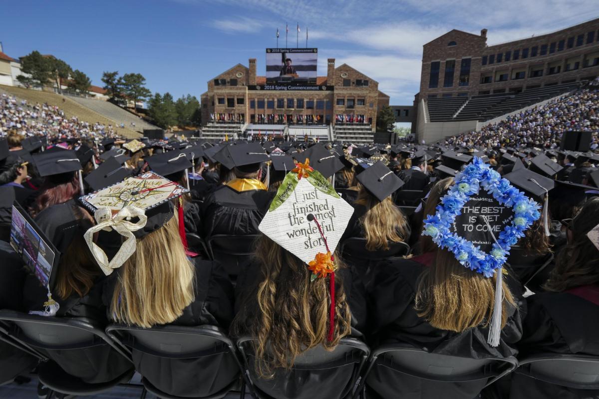 students sit on Folsom Field during 2018 commencement ceremony