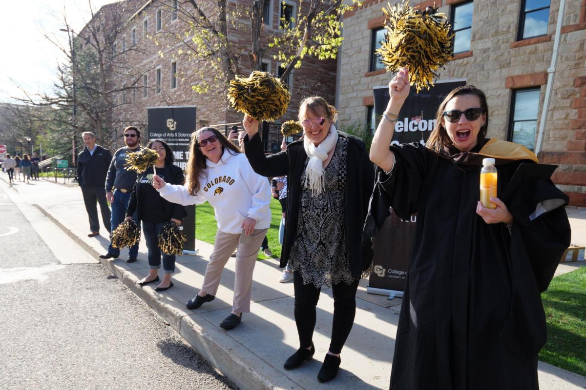 Students, parents, families, faculty, staff, guests and leadership cheer on 2022 graduates as they process to Folsom Field