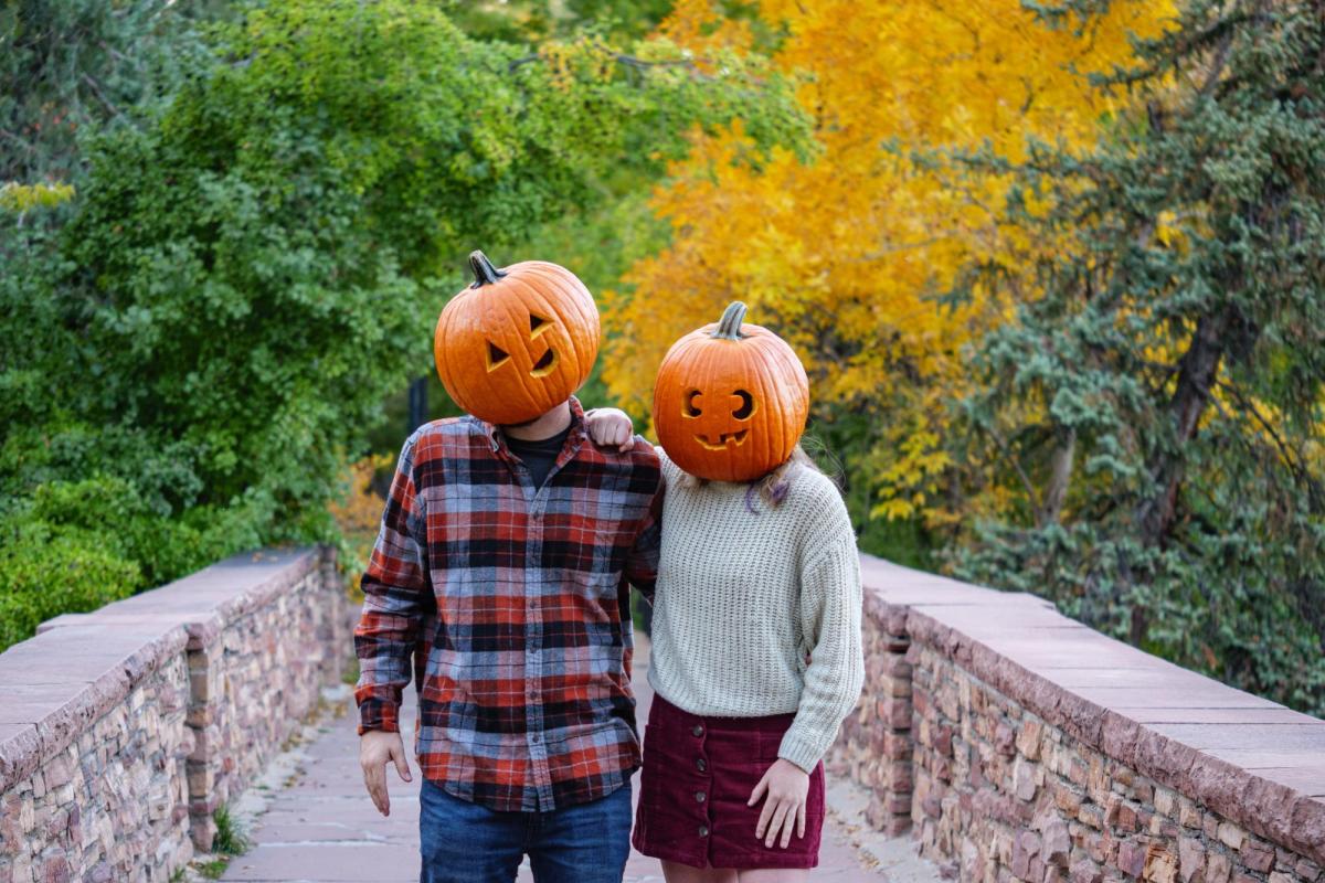 Students Mackenzie Hernandez and Nathan Smith don jack-o-lanterns on their heads