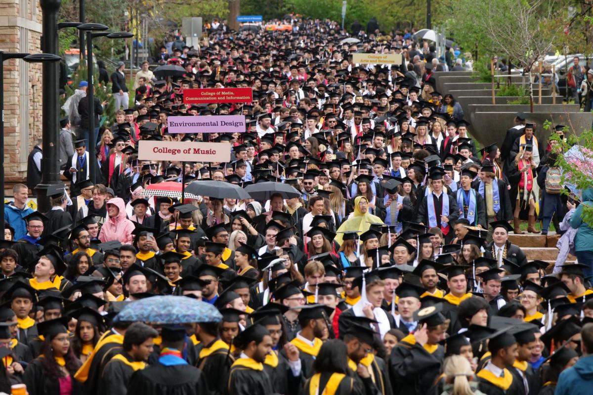 Graduates in mass numbers gather and process from the Norlin Quad. (Photo by Glenn J. Asakawa/University of Colorado)