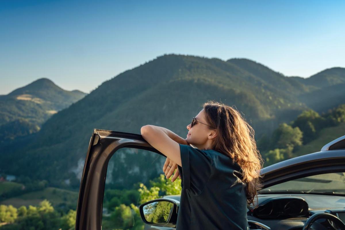 person traveling by car in the mountains during summer vacation