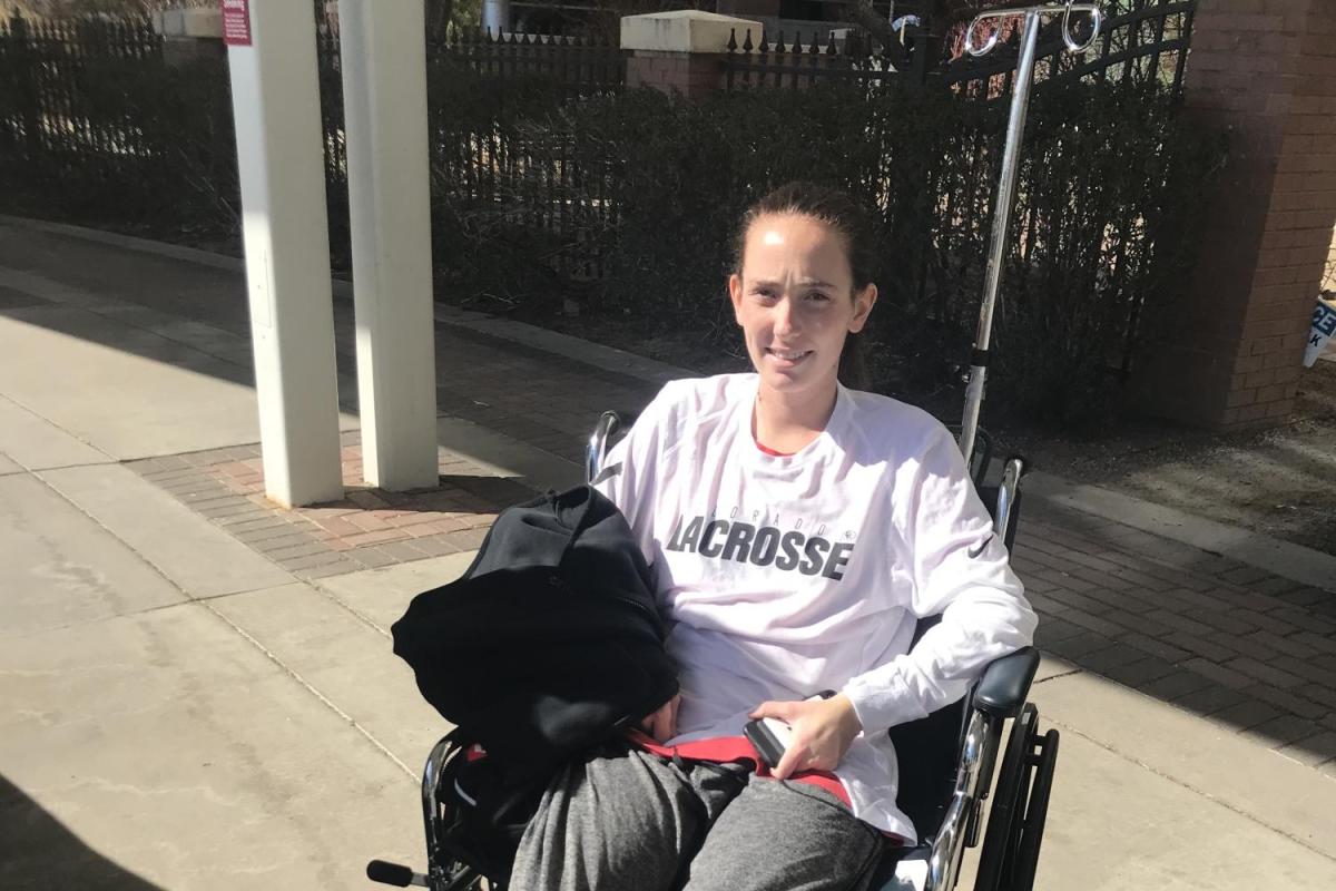 Aine Williams in wheelchair sporting a CU Lacrosse T-shirt