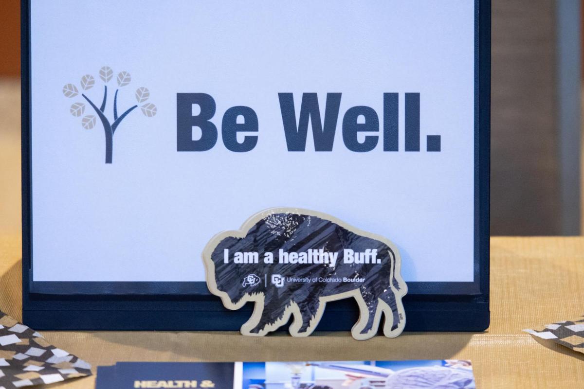 A Be Well sign on a table at a CU Boulder event.