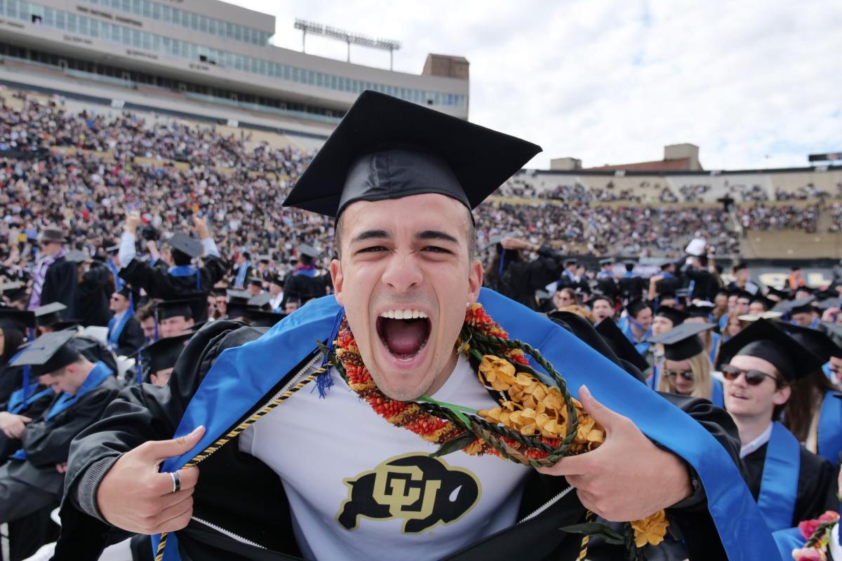 Graduate pulls a Superman, exposing a CU Buffs shirt under his robe